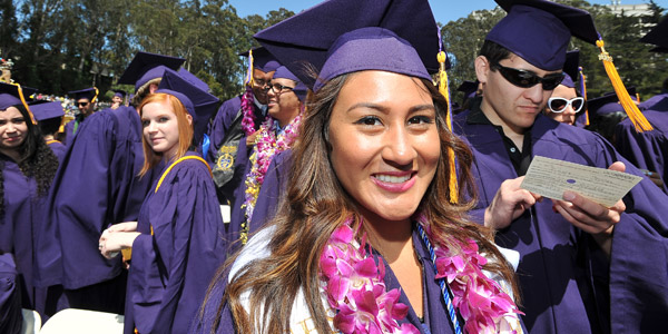 Female student at graduation in cap and gown smiling