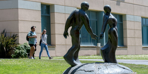 Bronze sculpture of male and female dancing on a partial globe